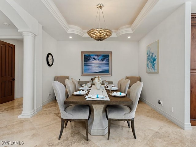 dining space featuring ornamental molding, baseboards, a tray ceiling, and decorative columns