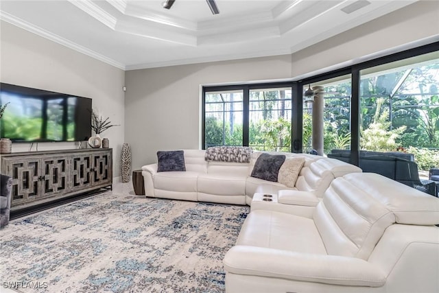 living room with crown molding, ceiling fan, carpet floors, and a tray ceiling