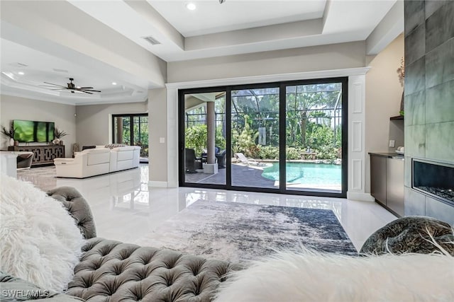 living room with a tray ceiling and ceiling fan