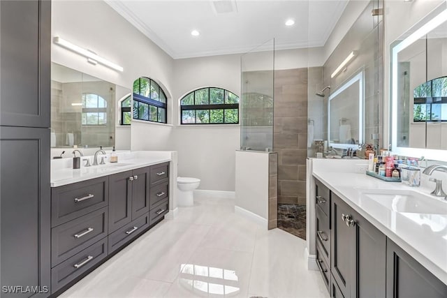 bathroom featuring crown molding, a tile shower, toilet, and vanity