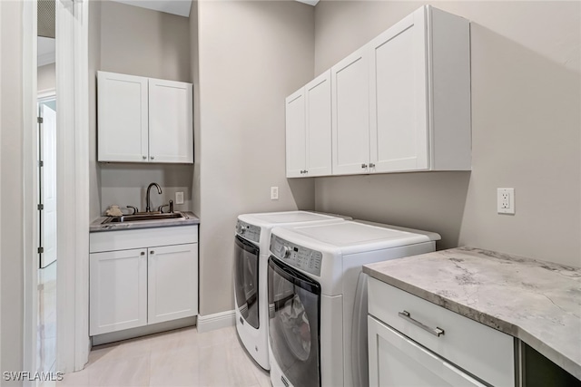 washroom featuring cabinets, light tile patterned floors, washer and clothes dryer, and sink