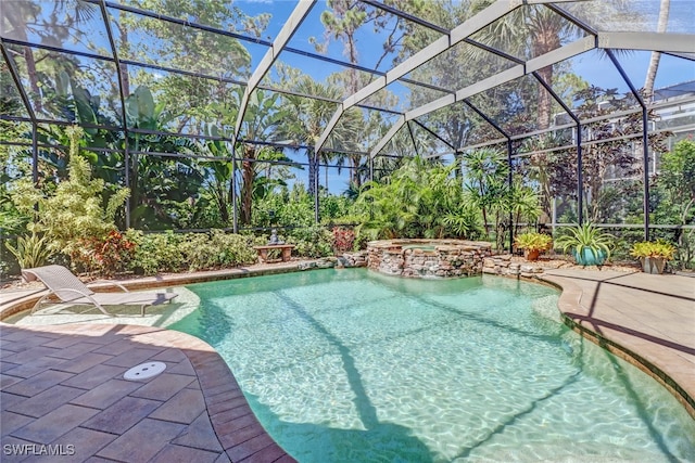 view of swimming pool featuring a patio, an in ground hot tub, and a lanai