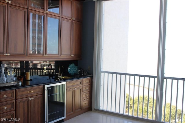 bar featuring beverage cooler, backsplash, a sink, and wet bar