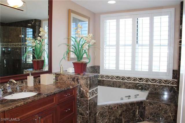 bathroom featuring a garden tub and vanity