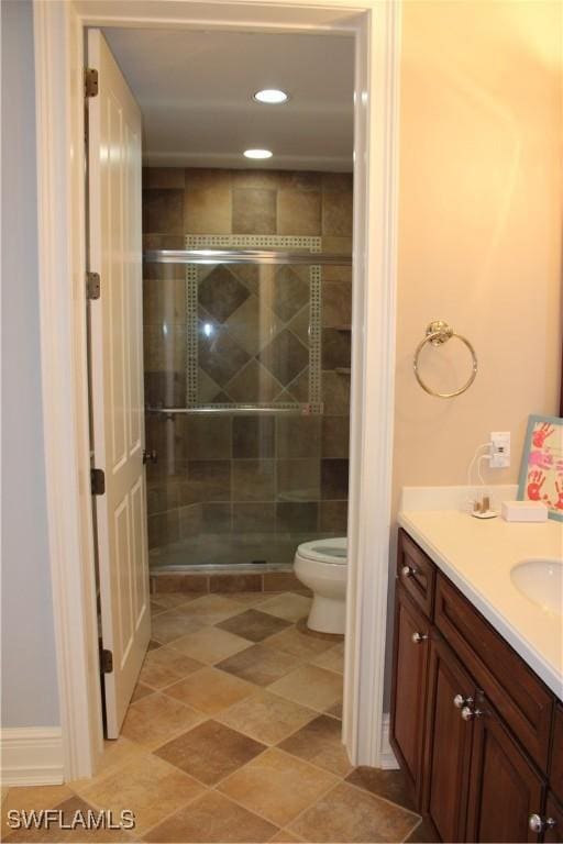 bathroom with toilet, a stall shower, recessed lighting, and vanity