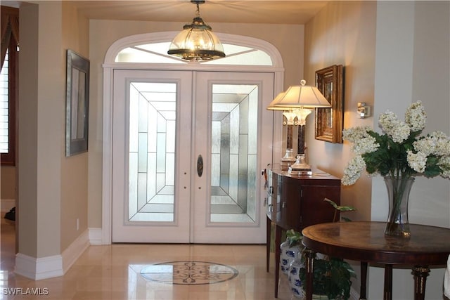 doorway with french doors and baseboards