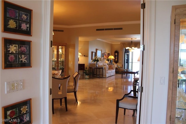 corridor with visible vents, a chandelier, and crown molding