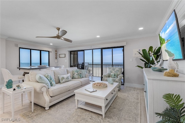 living room featuring light wood-style floors, ceiling fan, ornamental molding, and baseboards