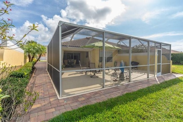 back of property featuring a patio and a lanai