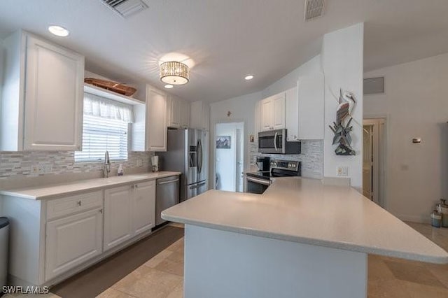 kitchen featuring appliances with stainless steel finishes, light countertops, white cabinets, and visible vents