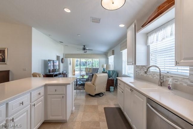 kitchen with a sink, white cabinetry, open floor plan, light countertops, and dishwasher