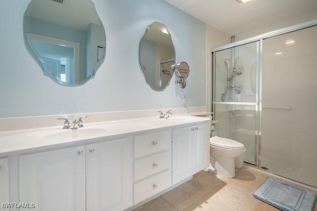 full bathroom with double vanity, tile patterned flooring, a sink, and a shower stall