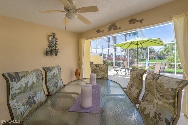 dining room with a sunroom, a textured ceiling, and a ceiling fan