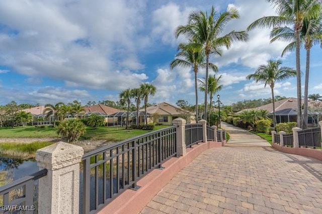 surrounding community featuring a water view, a residential view, and a gate