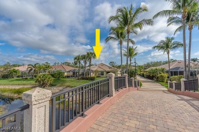 surrounding community with a water view, a residential view, and a gate