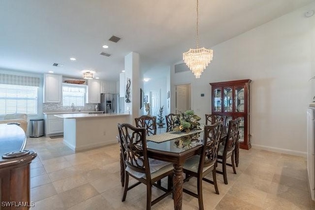 dining room featuring baseboards, a notable chandelier, and recessed lighting