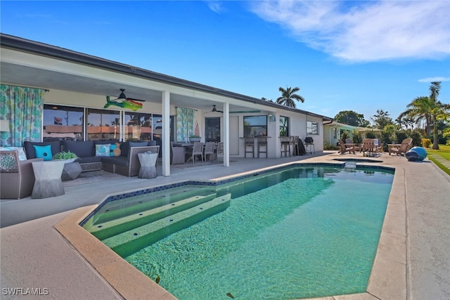 outdoor pool with ceiling fan, a patio, an outdoor bar, and an outdoor living space