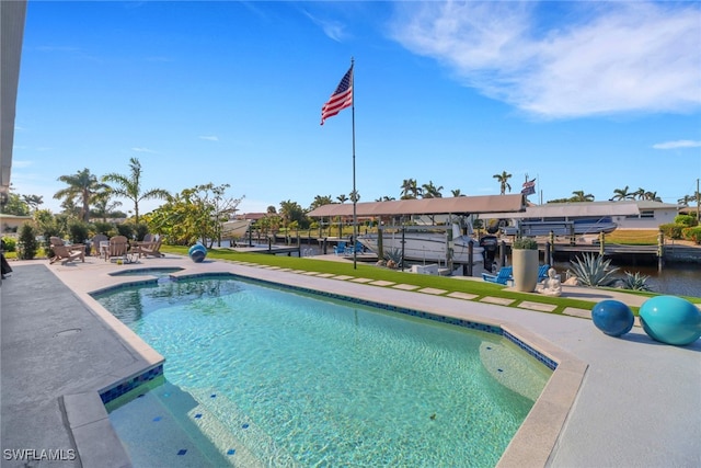 outdoor pool with a dock, a patio, and boat lift