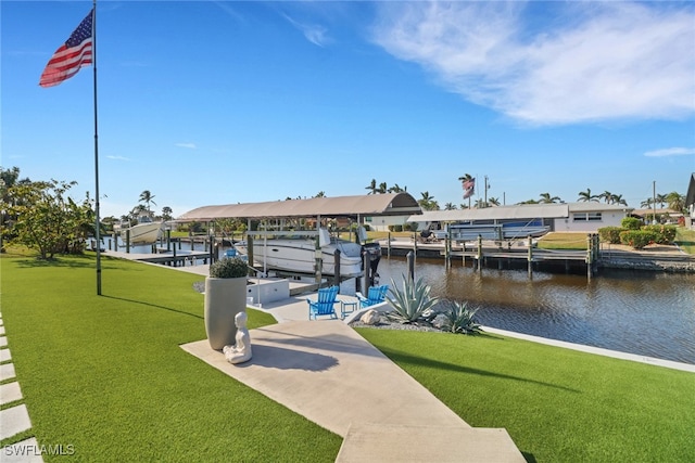 dock area with a water view, boat lift, and a yard