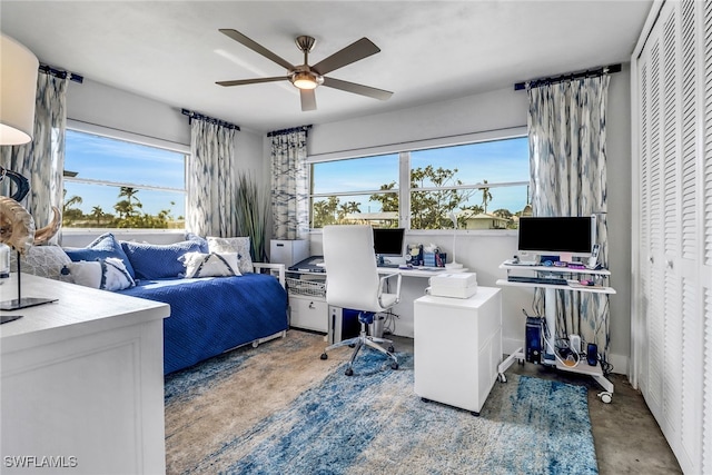 bedroom featuring concrete floors, a ceiling fan, and refrigerator