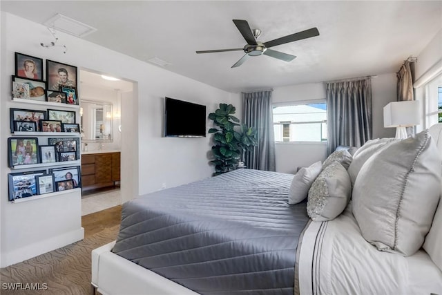 bedroom featuring visible vents, ensuite bathroom, attic access, a ceiling fan, and wood finished floors