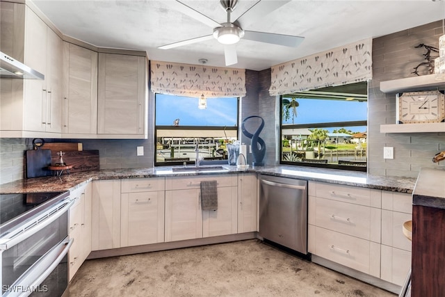 kitchen featuring open shelves, stainless steel appliances, backsplash, a sink, and dark stone countertops