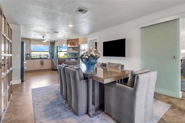 dining room featuring a wealth of natural light, visible vents, and finished concrete flooring