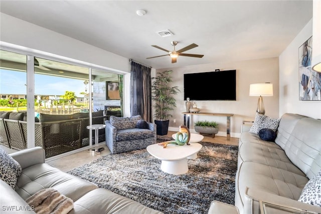 living area with baseboards, visible vents, and a ceiling fan