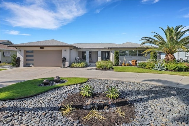 view of front of property with concrete driveway, an attached garage, and stucco siding