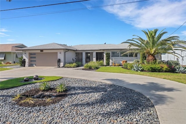 view of front of home featuring driveway, an attached garage, and stucco siding