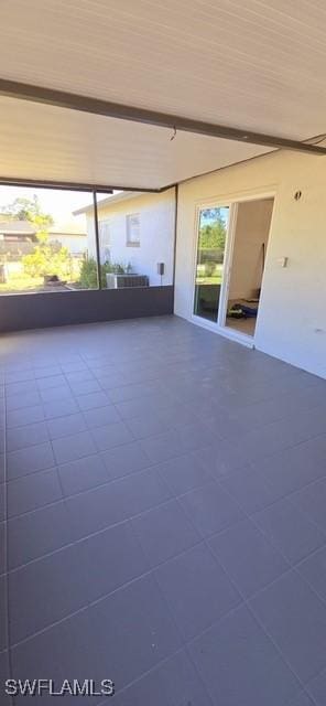 spare room with beamed ceiling and tile patterned flooring