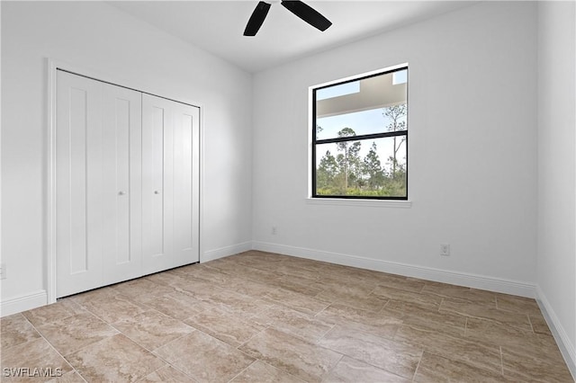 unfurnished bedroom with ceiling fan and a closet