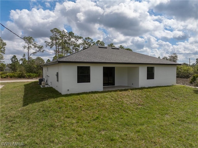 rear view of property featuring cooling unit and a yard