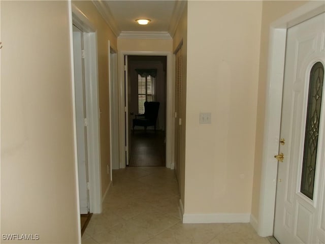 hallway featuring light tile patterned floors, baseboards, and crown molding