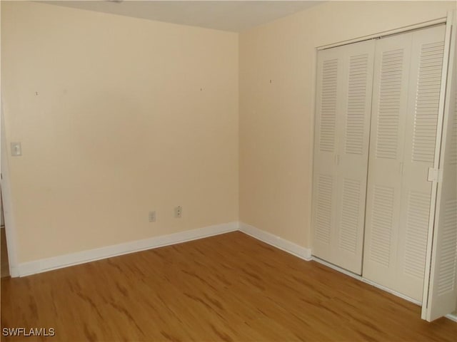 5447 Capbern Ct, Fort Myers, FL 33919 - unfurnished bedroom with baseboards, a closet, and wood finished floors