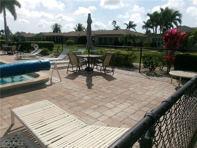 5447 Capbern Ct, Fort Myers, FL 33919 - view of patio with a jacuzzi, a community pool, and fence
