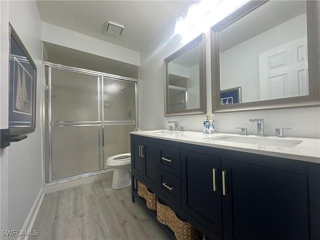 full bath featuring a shower stall, a sink, and wood finished floors