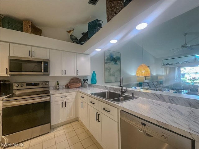 kitchen featuring appliances with stainless steel finishes, light countertops, a sink, and white cabinetry