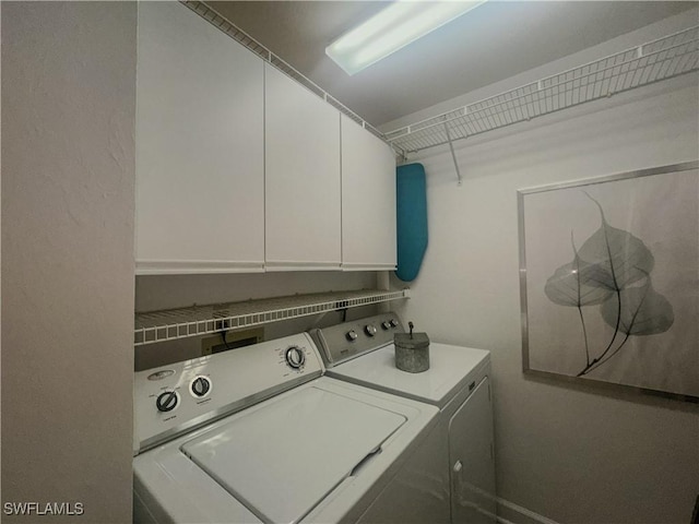 laundry area featuring separate washer and dryer and cabinet space