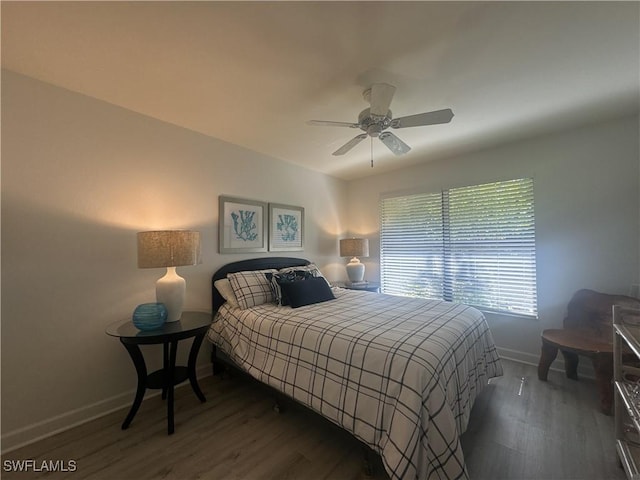 bedroom with ceiling fan, baseboards, and dark wood-style flooring