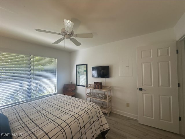 bedroom featuring a ceiling fan, baseboards, and wood finished floors