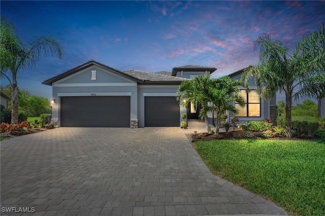 view of front facade with a front lawn, decorative driveway, an attached garage, and stucco siding