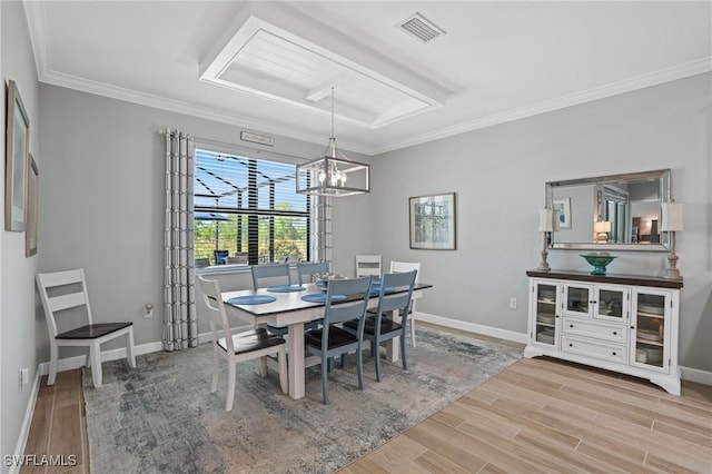 dining space featuring baseboards, visible vents, wood finished floors, and ornamental molding