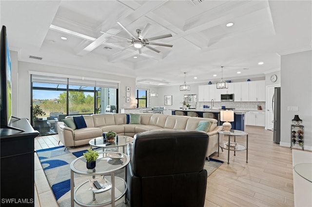 living area featuring light wood finished floors, visible vents, coffered ceiling, and beam ceiling