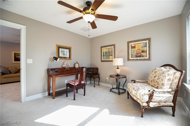 living area featuring light carpet, ceiling fan, and baseboards