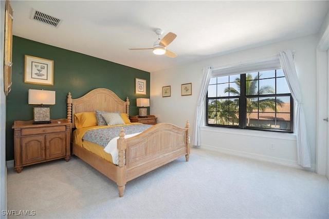 bedroom with baseboards, visible vents, ceiling fan, and light colored carpet