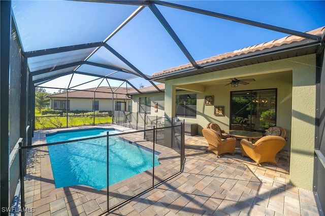 pool featuring a lanai, a patio area, and ceiling fan