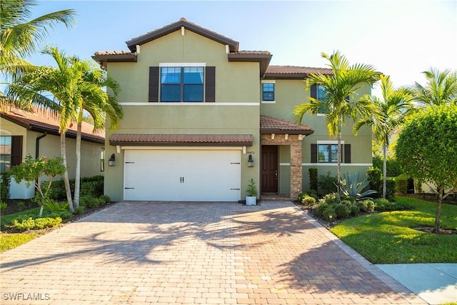 view of front of house with a garage, decorative driveway, a tile roof, and stucco siding