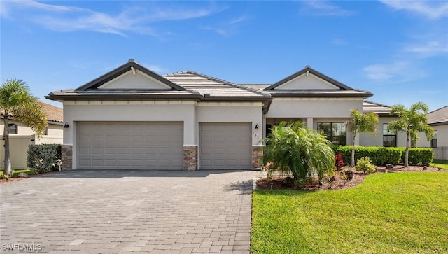 view of front of home with decorative driveway, stucco siding, an attached garage, stone siding, and a front lawn