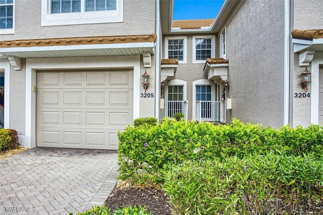 view of exterior entry featuring decorative driveway and stucco siding